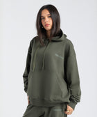 Model wearing the BROWNTOAST Core Hoodie from the Core Drop in olive green— a relaxed unisex hoodie with an adjustable drawstring hood, kangaroo pocket, and front silk-screen print. Made in Egypt from a soft cotton blend for an elevated everyday look.