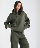  Model wearing the BROWNTOAST Core Hoodie from the Core Drop in olive green— a relaxed unisex hoodie with an adjustable drawstring hood, kangaroo pocket, and front silk-screen print. Made in Egypt from a soft cotton blend for an elevated everyday look.