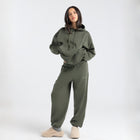  Model wearing the BROWNTOAST Core Hoodie from the Core Drop in olive green— a relaxed unisex hoodie with an adjustable drawstring hood, kangaroo pocket, and front silk-screen print. Made in Egypt from a soft cotton blend for an elevated everyday look.