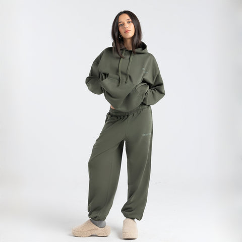  Model wearing the BROWNTOAST Core Hoodie from the Core Drop in olive green— a relaxed unisex hoodie with an adjustable drawstring hood, kangaroo pocket, and front silk-screen print. Made in Egypt from a soft cotton blend for an elevated everyday look.