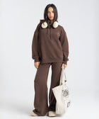 Model wearing the BROWNTOAST Core Hoodie from the Core Drop in coffee brown — a relaxed unisex hoodie with an adjustable drawstring hood, kangaroo pocket, and front silk-screen print. Made in Egypt from a soft cotton blend for an elevated everyday look.