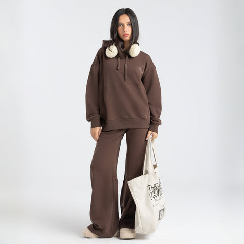 Model wearing the BROWNTOAST Core Hoodie from the Core Drop in coffee brown — a relaxed unisex hoodie with an adjustable drawstring hood, kangaroo pocket, and front silk-screen print. Made in Egypt from a soft cotton blend for an elevated everyday look.