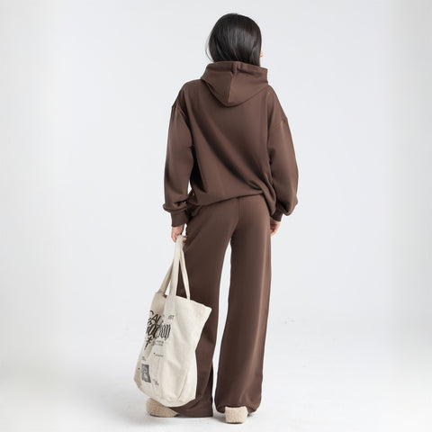 Model wearing the BROWNTOAST Core Hoodie from the Core Drop in coffee brown — a relaxed unisex hoodie with an adjustable drawstring hood, kangaroo pocket, and front silk-screen print. Made in Egypt from a soft cotton blend for an elevated everyday look.