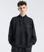 Model wearing the BROWNTOAST Core Hoodie from the Core Drop in black— a relaxed unisex hoodie with an adjustable drawstring hood, kangaroo pocket, and front silk-screen print. Made in Egypt from a soft cotton blend for an elevated everyday look.
