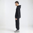  Model wearing the BROWNTOAST Core Hoodie from the Core Drop in black— a relaxed unisex hoodie with an adjustable drawstring hood, kangaroo pocket, and front silk-screen print. Made in Egypt from a soft cotton blend for an elevated everyday look.