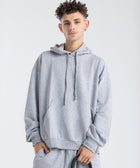 Model wearing the BROWNTOAST Core Hoodie from the Core Drop in light grey— a relaxed unisex hoodie with an adjustable drawstring hood, kangaroo pocket, and front silk-screen print. Made in Egypt from a soft cotton blend for an elevated everyday look.