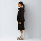 Model wearing the BROWNTOAST Core Long Shorts from the Core Drop in black — relaxed unisex cotton-lycra shorts with front piping detail, side pockets, and an adjustable drawstring waist. Knee-length design balancing bermuda and short fit, made in Egypt for everyday comfort and style.