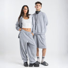 Model wearing the BROWNTOAST Core Long Shorts from the Core Drop in light grey — relaxed unisex cotton-lycra shorts with front piping detail, side pockets, and an adjustable drawstring waist. Knee-length design balancing bermuda and short fit, made in Egypt for everyday comfort and style.