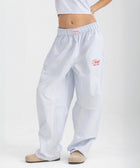 Unisex wide-leg striped cotton pants in ocean blue and white, relaxed slouchy fit, modeled with casual summer outfit.