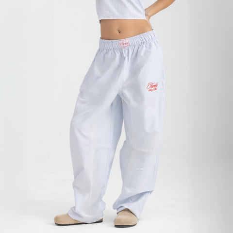 Unisex wide-leg striped cotton pants in ocean blue and white, relaxed slouchy fit, modeled with casual summer outfit.