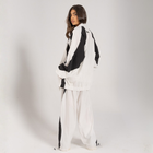 Model wearing the BROWNTOAST Compton Tracksuit Jacket — unisex oversized polyester track jacket with a dual-function zipper and BTO rubber and embroidered logos. Inspired by old-school Compton style and 80s hip-hop culture. Available in black and white.