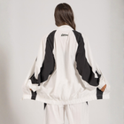 Model wearing the BROWNTOAST Compton Tracksuit Jacket — unisex oversized polyester track jacket with a dual-function zipper and BTO rubber and embroidered logos. Inspired by old-school Compton style and 80s hip-hop culture. Available in black and white.