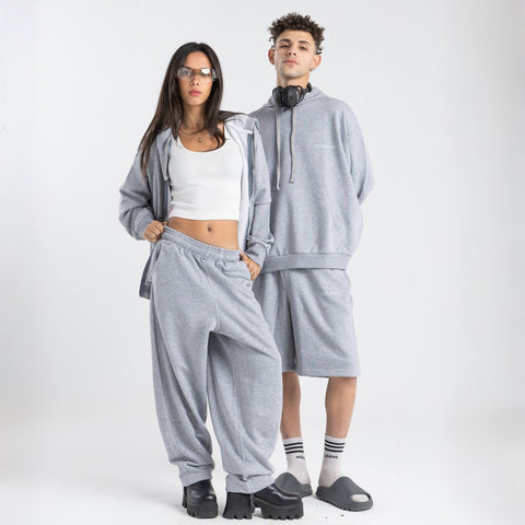 Model wearing the BROWNTOAST Core Barrel Sweats from the Core Drop — unisex cotton sweatpants in light grey with a relaxed barrel-shaped leg, elastic waistband, and side pockets. Made in Egypt for structured comfort and clean everyday style.