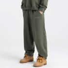 Model wearing the BROWNTOAST Core Barrel Sweats from the Core Drop — unisex cotton sweatpants in light grey with a relaxed barrel-shaped leg, elastic waistband, and side pockets. Made in Egypt for structured comfort and clean everyday style.