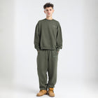 Model wearing the BROWNTOAST Core Barrel Sweats from the Core Drop — unisex cotton sweatpants in light grey with a relaxed barrel-shaped leg, elastic waistband, and side pockets. Made in Egypt for structured comfort and clean everyday style.