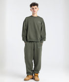 Model wearing the BROWNTOAST Core Barrel Sweats from the Core Drop — unisex cotton sweatpants in light grey with a relaxed barrel-shaped leg, elastic waistband, and side pockets. Made in Egypt for structured comfort and clean everyday style.