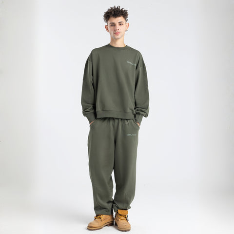 Model wearing the BROWNTOAST Core Barrel Sweats from the Core Drop — unisex cotton sweatpants in light grey with a relaxed barrel-shaped leg, elastic waistband, and side pockets. Made in Egypt for structured comfort and clean everyday style.