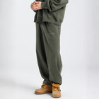 Model wearing the BROWNTOAST Core Barrel Sweats from the Core Drop — unisex cotton sweatpants in light grey with a relaxed barrel-shaped leg, elastic waistband, and side pockets. Made in Egypt for structured comfort and clean everyday style.