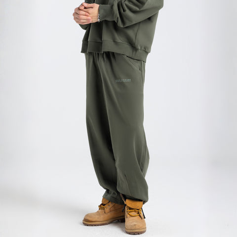 Model wearing the BROWNTOAST Core Barrel Sweats from the Core Drop — unisex cotton sweatpants in light grey with a relaxed barrel-shaped leg, elastic waistband, and side pockets. Made in Egypt for structured comfort and clean everyday style.