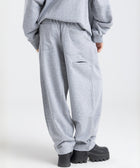 Model wearing the BROWNTOAST Core Barrel Sweats from the Core Drop — unisex cotton sweatpants in light grey with a relaxed barrel-shaped leg, elastic waistband, and side pockets. Made in Egypt for structured comfort and clean everyday style.