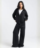 Model wearing the BROWNTOAST Core Flared Sweats from the Core Drop — women’s cotton-lycra flared sweatpants with a mid-rise waist, adjustable drawstring, and subtle seam detailing. Made in Egypt for a soft, flattering, and effortless everyday look. In black color.