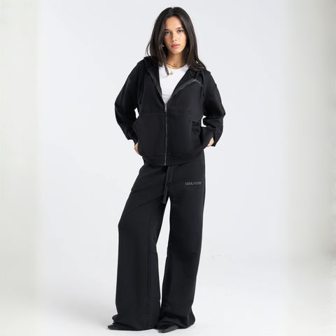 Model wearing the BROWNTOAST Core Flared Sweats from the Core Drop — women’s cotton-lycra flared sweatpants with a mid-rise waist, adjustable drawstring, and subtle seam detailing. Made in Egypt for a soft, flattering, and effortless everyday look. In black color.