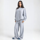 Model wearing the BROWNTOAST Core Flared Sweats from the Core Drop — women’s cotton-lycra flared sweatpants with a mid-rise waist, adjustable drawstring, and subtle seam detailing. Made in Egypt for a soft, flattering, and effortless everyday look. In light grey color.