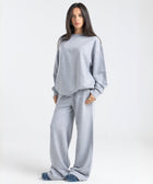 Model wearing the BROWNTOAST Core Flared Sweats from the Core Drop — women’s cotton-lycra flared sweatpants with a mid-rise waist, adjustable drawstring, and subtle seam detailing. Made in Egypt for a soft, flattering, and effortless everyday look. In light grey color.