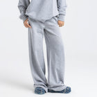 Model wearing the BROWNTOAST Core Flared Sweats from the Core Drop — women’s cotton-lycra flared sweatpants with a mid-rise waist, adjustable drawstring, and subtle seam detailing. Made in Egypt for a soft, flattering, and effortless everyday look. In light grey color.