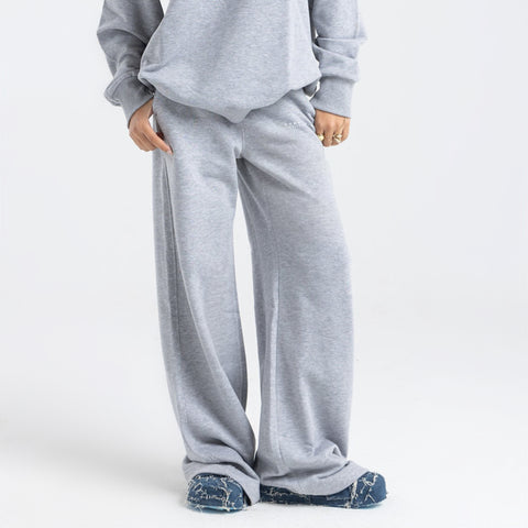 Model wearing the BROWNTOAST Core Flared Sweats from the Core Drop — women’s cotton-lycra flared sweatpants with a mid-rise waist, adjustable drawstring, and subtle seam detailing. Made in Egypt for a soft, flattering, and effortless everyday look. In light grey color.