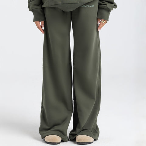 Model wearing the BROWNTOAST Core Flared Sweats from the Core Drop — women’s cotton-lycra flared sweatpants with a mid-rise waist, adjustable drawstring, and subtle seam detailing. Made in Egypt for a soft, flattering, and effortless everyday look. In olive green color.