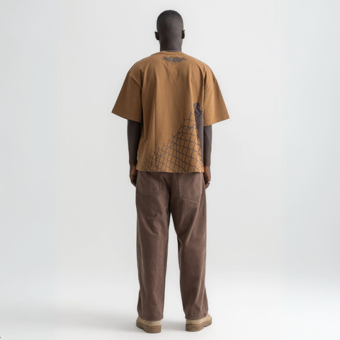 Back view of burnt brown cotton t-shirt featuring broken chain-link fence print.