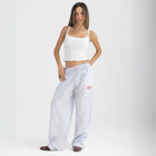 Unisex wide-leg striped cotton pants in ocean blue and white, relaxed slouchy fit, modeled with casual summer outfit.