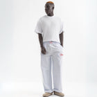 Unisex wide-leg striped cotton pants in ocean blue and white, relaxed slouchy fit, modeled with casual summer outfit.