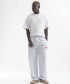 Unisex wide-leg striped cotton pants in ocean blue and white, relaxed slouchy fit, modeled with casual summer outfit.