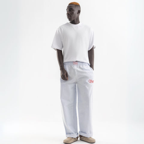 Unisex wide-leg striped cotton pants in ocean blue and white, relaxed slouchy fit, modeled with casual summer outfit.