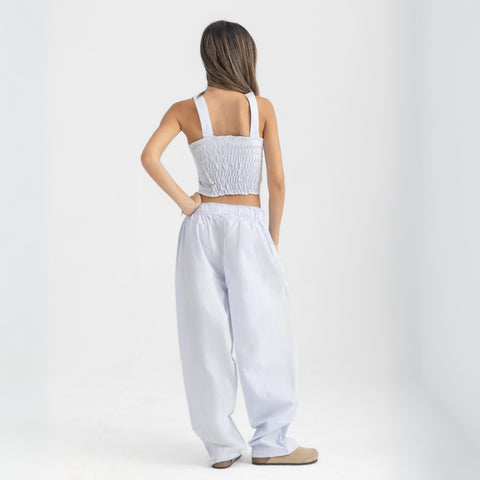 Unisex wide-leg striped cotton pants in ocean blue and white, relaxed slouchy fit, modeled with casual summer outfit.