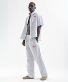 Unisex wide-leg striped cotton pants in ocean blue and white, relaxed slouchy fit, modeled with casual summer outfit.