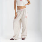 Unisex wide-leg striped cotton pants in beige and white, relaxed slouchy fit, modeled with casual summer outfit.