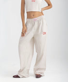 Unisex wide-leg striped cotton pants in beige and white, relaxed slouchy fit, modeled with casual summer outfit.