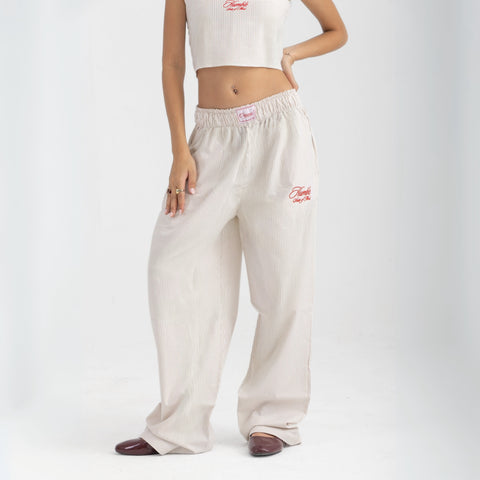 Unisex wide-leg striped cotton pants in beige and white, relaxed slouchy fit, modeled with casual summer outfit.