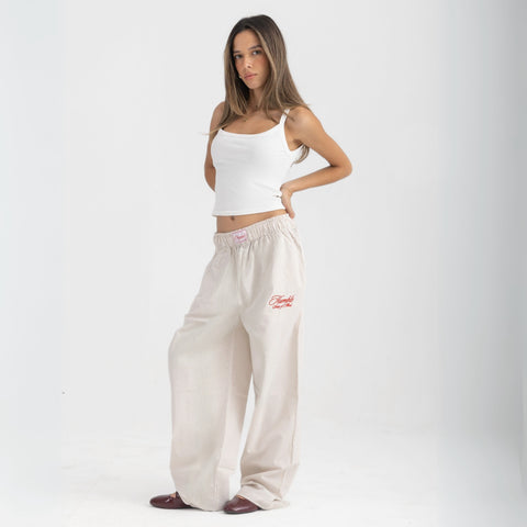 Unisex wide-leg striped cotton pants in beige and white, relaxed slouchy fit, modeled with casual summer outfit.