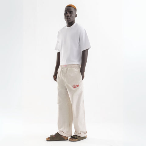 Unisex wide-leg striped cotton pants in beige and white, relaxed slouchy fit, modeled with casual summer outfit.