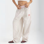 Unisex wide-leg striped cotton pants in beige and white, relaxed slouchy fit, modeled with casual summer outfit.