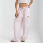 Unisex wide-leg striped cotton pants in pink and white, relaxed slouchy fit, modeled with casual summer outfit.