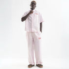 Unisex wide-leg striped cotton pants in pink and white, relaxed slouchy fit, modeled with casual summer outfit.