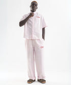 Unisex wide-leg striped cotton pants in pink and white, relaxed slouchy fit, modeled with casual summer outfit.