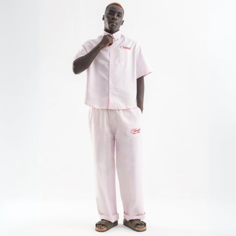 Unisex wide-leg striped cotton pants in pink and white, relaxed slouchy fit, modeled with casual summer outfit.