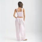 Unisex wide-leg striped cotton pants in pink and white, relaxed slouchy fit, modeled with casual summer outfit.