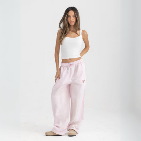 Unisex wide-leg striped cotton pants in pink and white, relaxed slouchy fit, modeled with casual summer outfit.